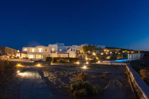 a group of buildings at night with lights at Aegean Stones in Agios Ioannis Mykonos