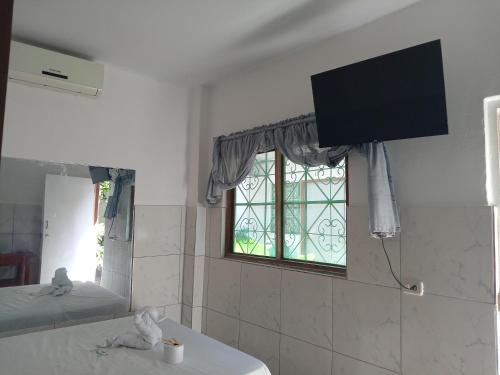 uma casa de banho com uma televisão na parede e uma janela em Misti em Tarapoto