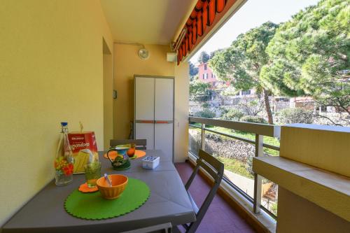 une cuisine avec une table et un balcon avec vue dans l'établissement Studio St Jean à Roquebrune, proche Menton et Monaco, à Roquebrune-Cap-Martin