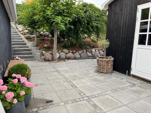 a patio with a bunch of flowers and a door at Charming holiday home on the harbour (5 persons) in Rødvig