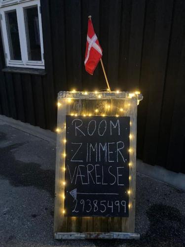 a sign with a flag and a sign with lights at Charming holiday home on the harbour (5 persons) in Rødvig
