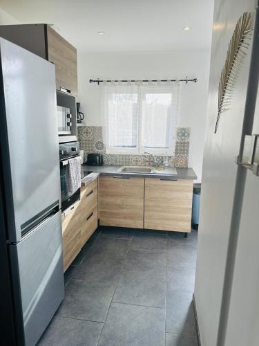 La cuisine est équipée d'un réfrigérateur et d'un évier. dans l'établissement Gîte la volette, à Intraville