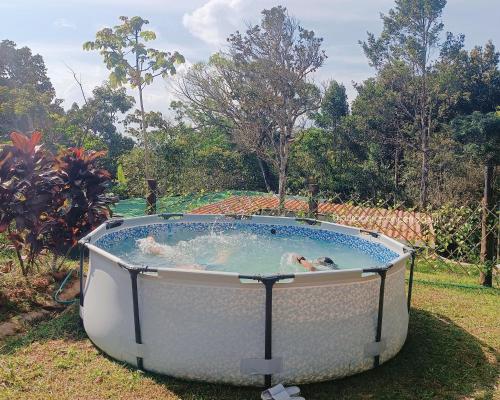 a hot tub with two people in it in a yard at Cabaña de Montaña Puro Corazón in Los Altos de Cerro Azul