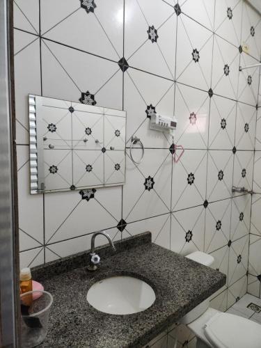 a bathroom with a sink and a tiled wall at Casa favorita in São Raimundo Nonato