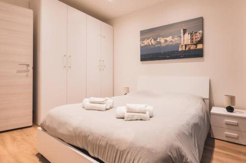een witte slaapkamer met een bed met handdoeken erop bij [Ospedale Maggiore] Vidali Elegant Suite *Netflix* in Trieste