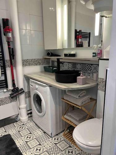 une salle de bain avec machine à laver et toilettes dans l'établissement Charmant studio Paris 17ème, à Paris