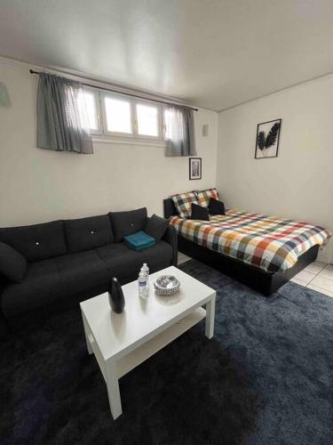 un salon avec un canapé et une table basse dans l'établissement Charmant studio Paris 17ème, à Paris