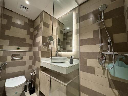 a bathroom with a toilet and a sink and a shower at Beachside Bliss: Stylish New Studio at Seven Palm in Dubai