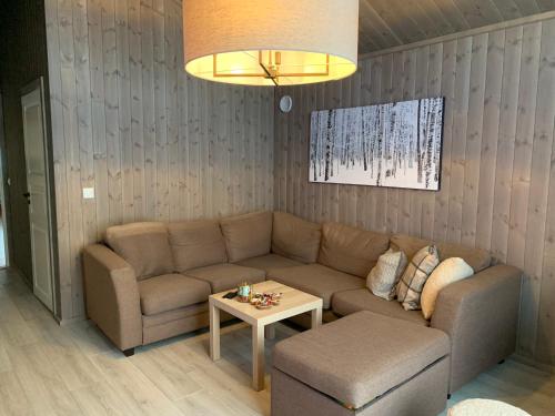 a living room with a couch and a table at Beautiful cabin close to activities in Trysil, Trysilfjellet, with Sauna, 4 Bedrooms, 2 bathrooms and Wifi in Trysil