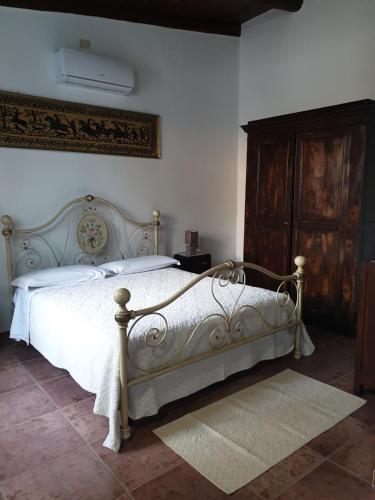 1 dormitorio con cama blanca y armario de madera en Azienda agricola Affittacamere S'Ispinalba di Laura Pitzolu, en Borore