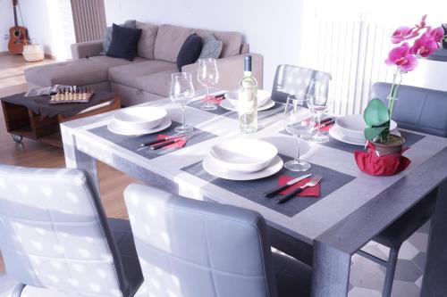 a dining room table with plates and wine glasses at Casa Bellavista-Spazioso appartamento in collina a due passi da Bergamo in Sorisole