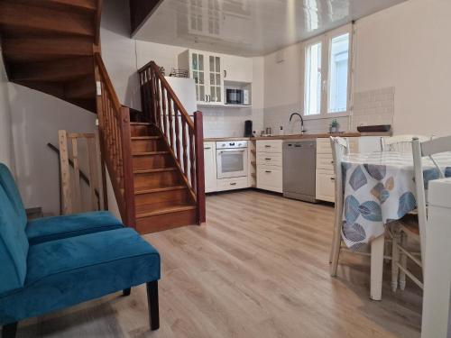 une cuisine avec un escalier et une cuisine avec un évier et une table dans l'établissement Logement à deux pas de la plage et des commerces, au Tréport