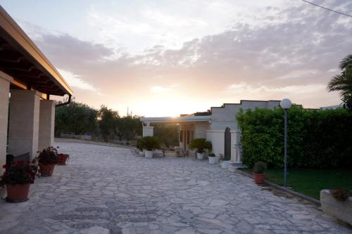 a stone driveway in front of a building with a sunset at Agriturismo Nonna Rosa in Matera