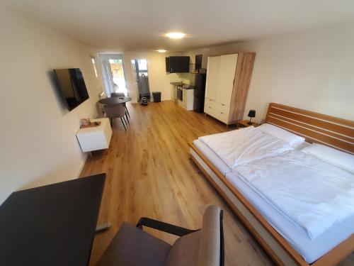 a bedroom with a large bed and a wooden floor at Ferienwohnung Blumenstiel in Maikammer