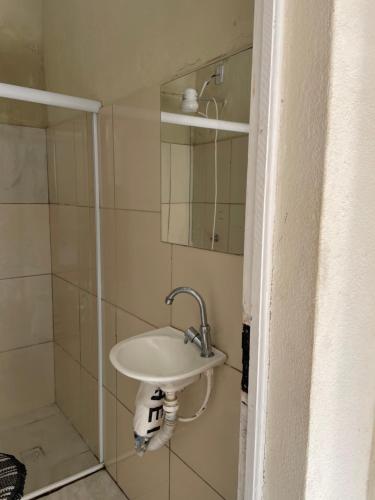uma casa de banho com um lavatório e um chuveiro em Pelinca Suite em Campos dos Goytacazes