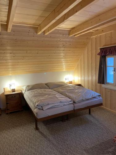 捷克布傑約維採的住宿－Chaloupka，木天花板的客房内的一张床位