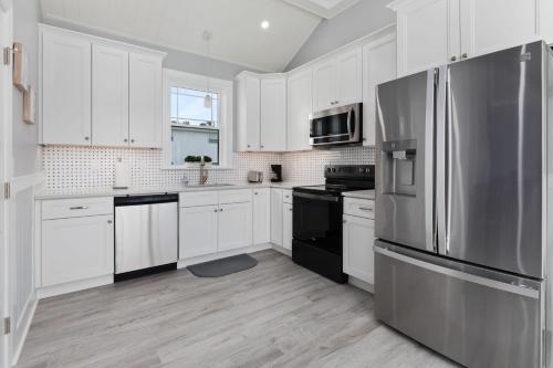 a kitchen with white cabinets and a stainless steel refrigerator at 204 E Primrose Unit 201 in Wildwood