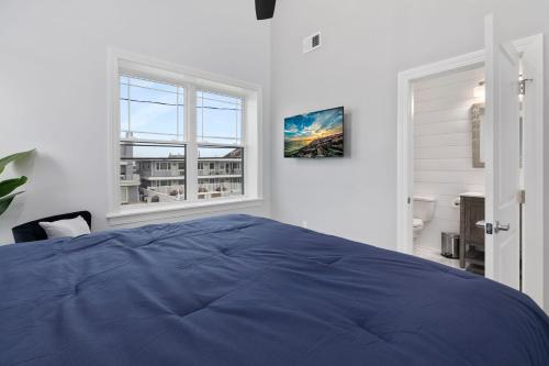 a bedroom with a blue bed and two windows at 204 E Primrose Unit 201 in Wildwood