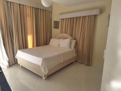 sypialnia z łóżkiem z białą pościelą i poduszkami w obiekcie Ocean view superior w mieście Juan Pedro