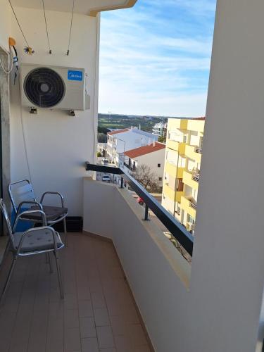 a balcony with two chairs and a air conditioner at OCEAN VIEW Quartos in Faro
