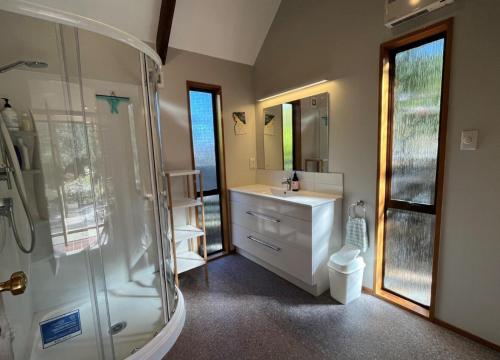 a bathroom with a shower and a sink and a toilet at 90 Chalet Crescent in Hanmer Springs