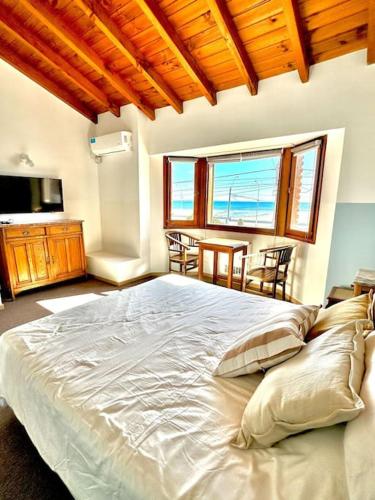 a bedroom with a large bed and a table with chairs at Chalet Alberdi in Puerto Madryn
