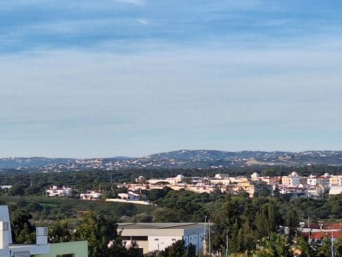 a view of a city with houses and trees at OCEAN VIEW Quartos in Faro
