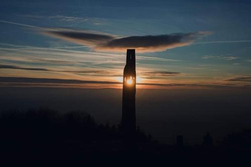 a silhouette of a tower in the sky with the sunset at Červený Stylový Apartmán 3 km od Malé Skály in Koberovy