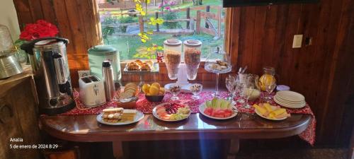 una mesa con platos de comida. en Lago Gutierrez en San Carlos de Bariloche