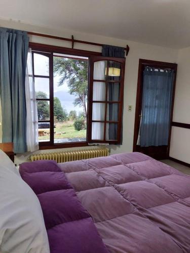 1 cama grande en un dormitorio con ventana grande en Lago Gutierrez en San Carlos de Bariloche