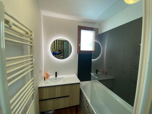 a bathroom with a sink and a tub and a mirror at Chalet 6 / 8 personnes Super Dévoluy in Superdevoluy