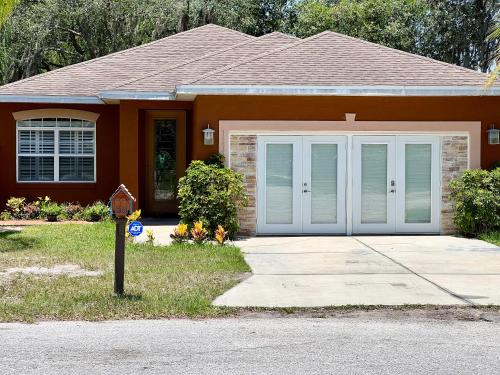 a house with a garage and a parking meter in front of it at The Tatman Evergreen Suite in Lake Alfred