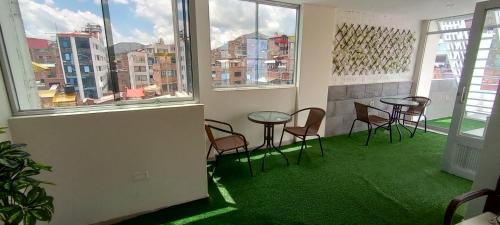 a room with chairs and a table and windows at MADA Guest House Puno "Hospedaje" in Puno