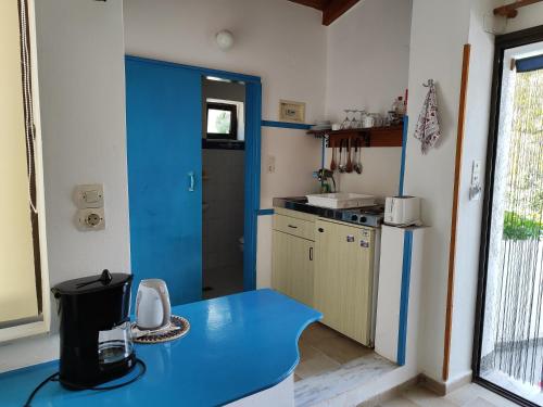 a kitchen with a blue counter top in a room at Oleander's Garden Traditional Cretan Cottage in Ferma