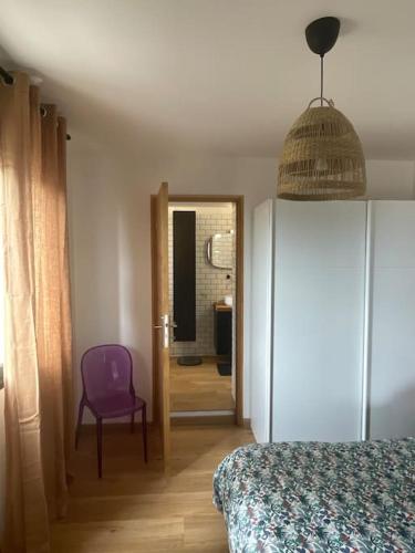 Cette chambre comprend un lit et une chaise violette. dans l'établissement le cap, à San-Martino-di-Lota