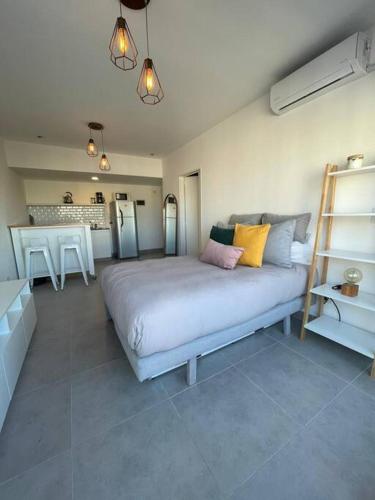 a bedroom with a large bed and a kitchen at Departamento Palermo Hollywood monoambiente in Buenos Aires