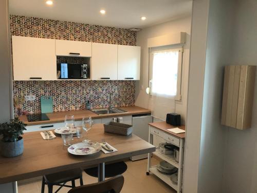- une cuisine avec une table en bois et des verres dans l'établissement En plein cœur de Port en Bessin - Côté Mer, à Port-en-Bessin-Huppain