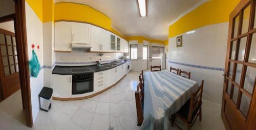 a large room with a kitchen with a table in it at OCEAN VIEW Quartos in Faro