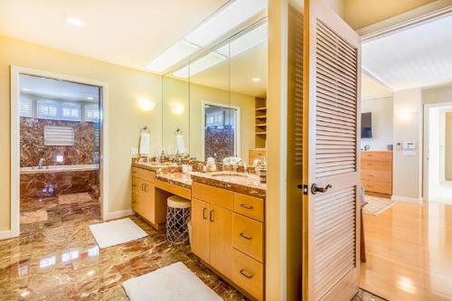 een badkamer met 2 wastafels en een grote spiegel bij Villa Ahina in Honolulu