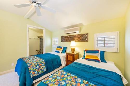 1 dormitorio con 2 camas y ventilador de techo en Villa Ahina en Honolulu