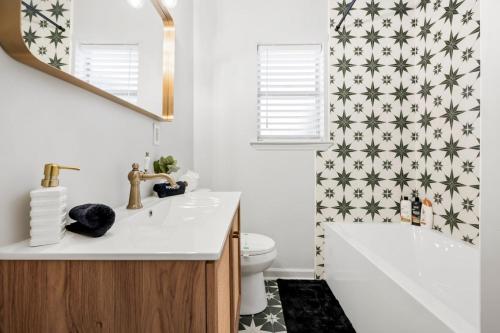 a bathroom with a sink and a toilet and a mirror at Near River St, Forsyth & DT - Stylish - Free Parking in Savannah