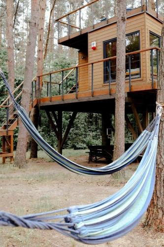a hammock in front of a tree house at Domek na Drzewie Radziejowice blisko Suntago in Budy Mszczonowskie