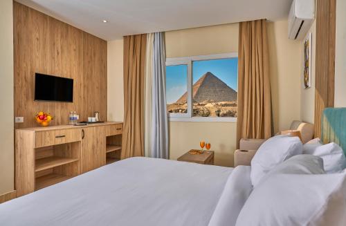 a hotel room with a bed and a view of the pyramid at Soul Pyramids View in Cairo