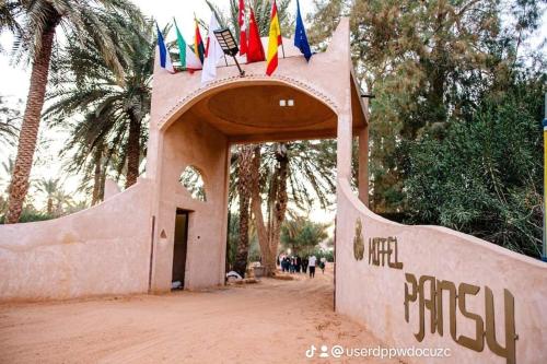 a small building with flags on top of it at Hotel Pansy in Ksar Ghilane