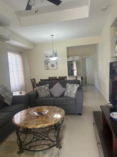 a living room with a couch and a table at Seamist villa @Oceanpointe Lucea comfy 2BR w/pool gym & parking in Lucea
