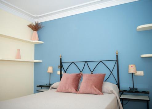 sypialnia z łóżkiem z niebieską ścianą w obiekcie Casa Rural El Camino de Yuste w mieście Cuacos de Yuste