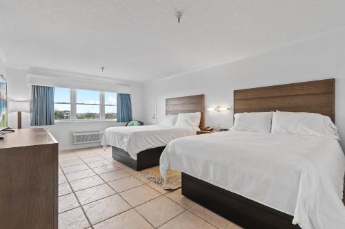 a hotel room with two beds and a window at Ocean Isle Inn in Ocean Isle Beach