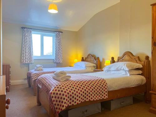 a bedroom with two beds and a window at Hill Cottage, Braithwaite in Braithwaite