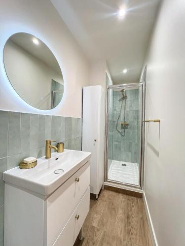 une salle de bain blanche avec un lavabo et une douche dans l'établissement Charmant Appartement - Avec Balcon & Climatisation - Les Frères de la Loc', à Marseille