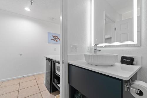 ein weißes Badezimmer mit einem Waschbecken und einer Theke in der Unterkunft Ocean Isle Inn in Ocean Isle Beach